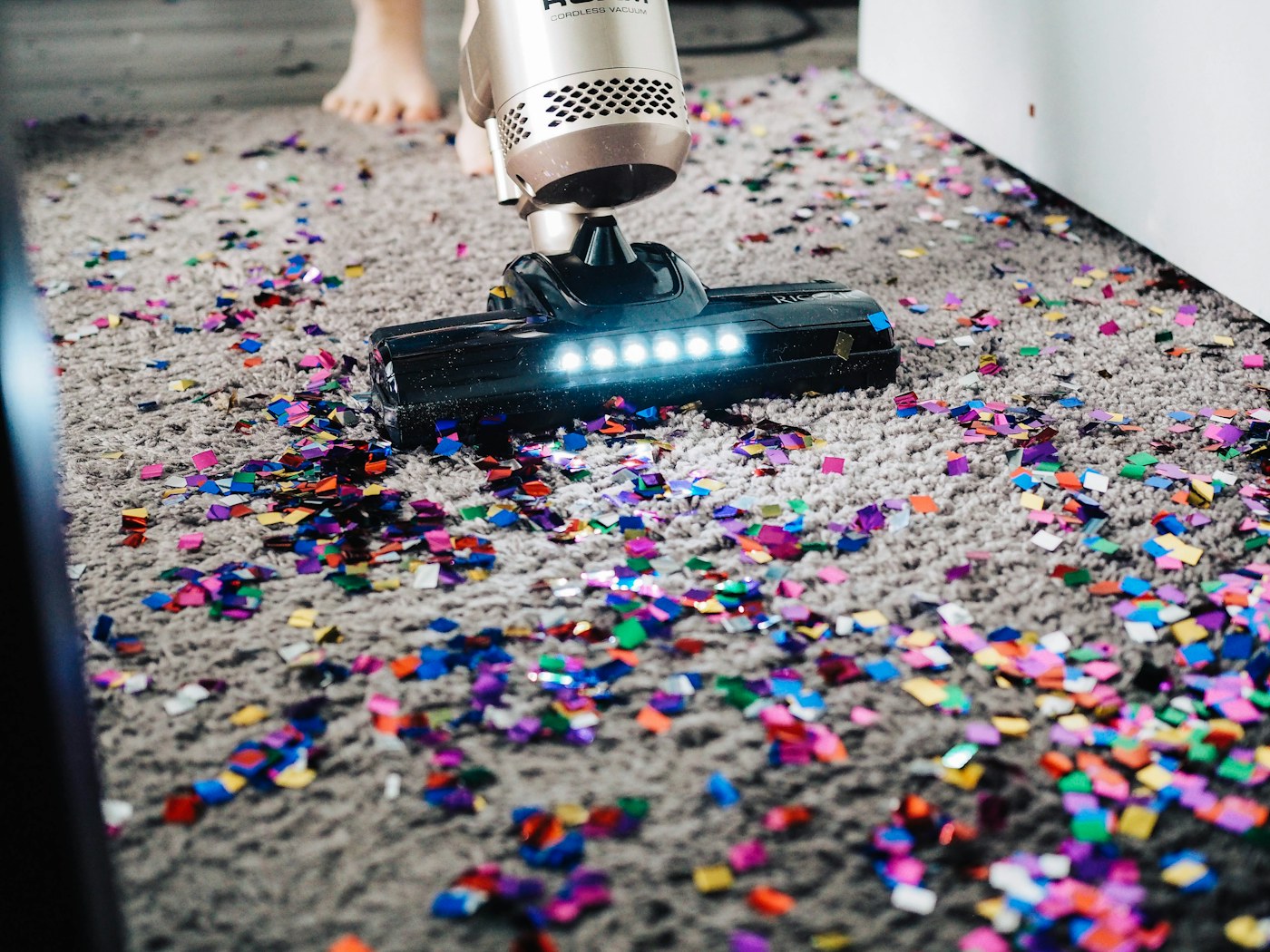 Person carrying a compact cleaning caddy through a bright home