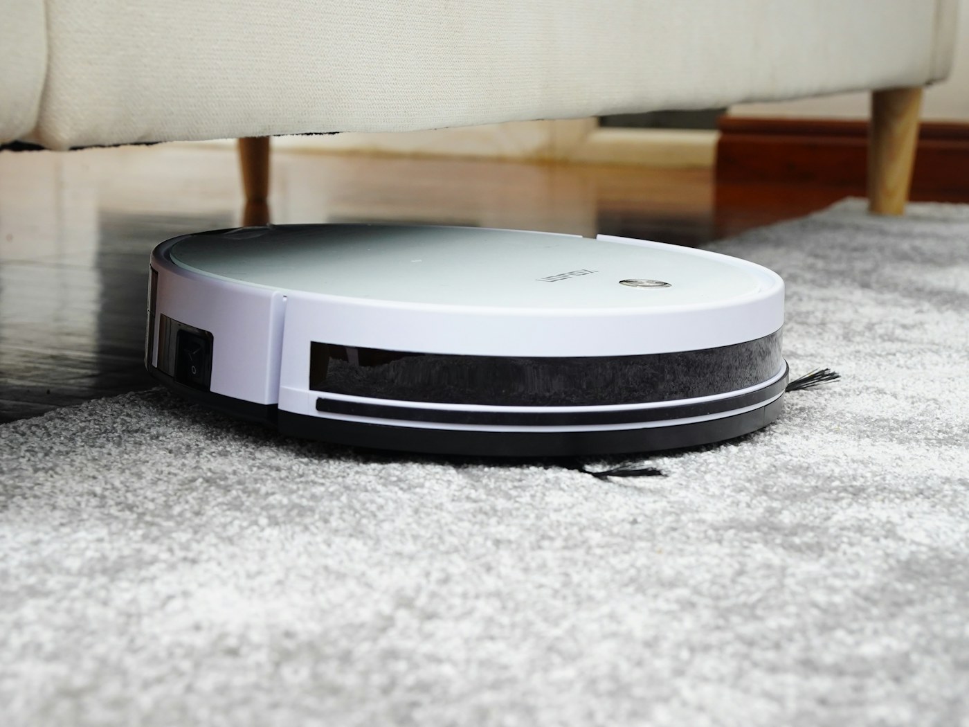 Person using a cordless vacuum in a lived-in apartment