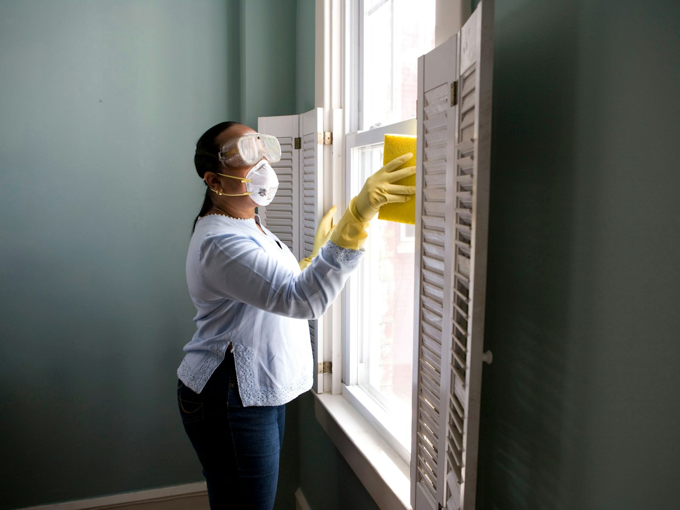 Parent mopping a bright family kitchen with a pet nearby