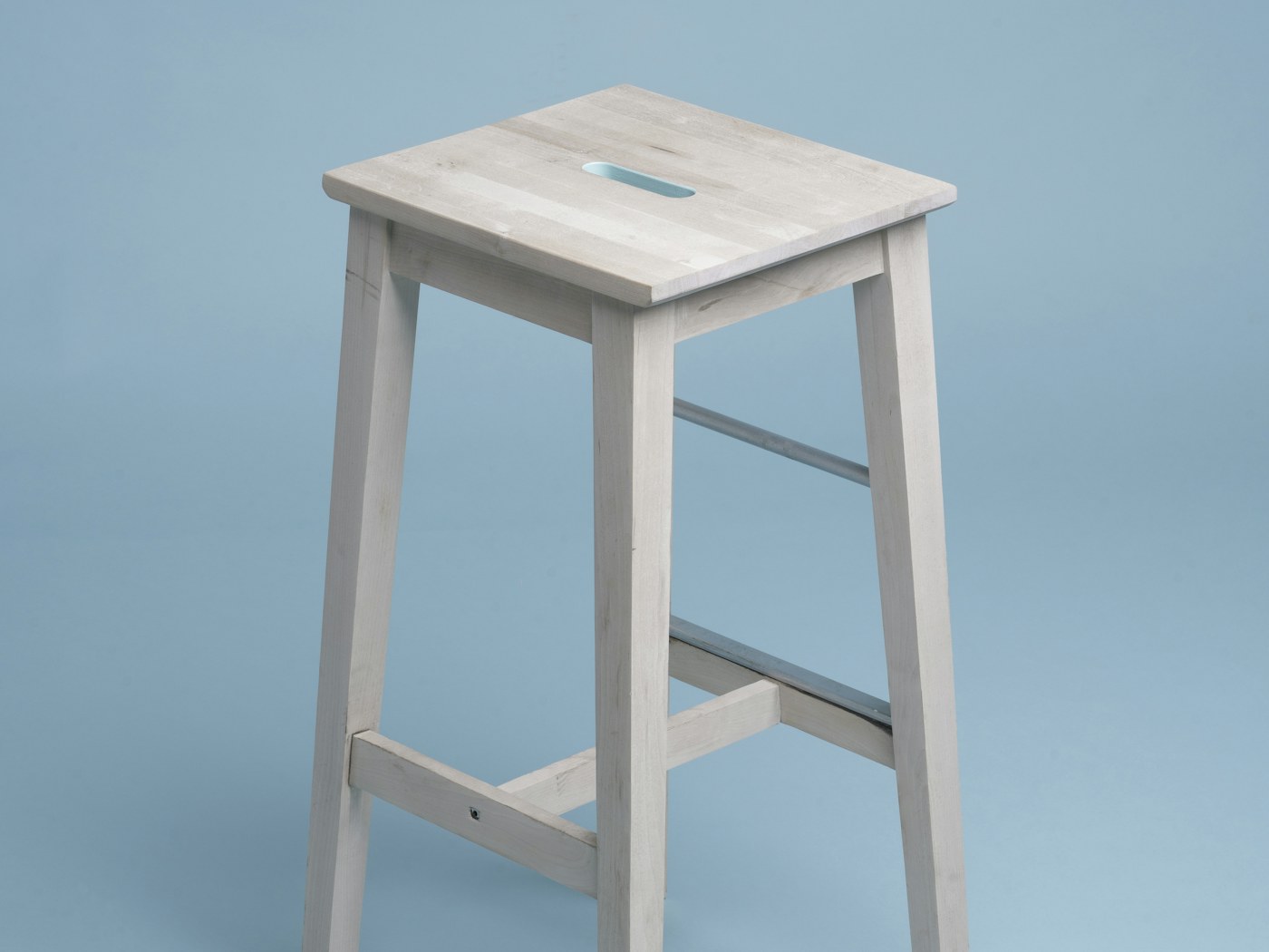 Adult using a stable folding step stool to reach a kitchen shelf
